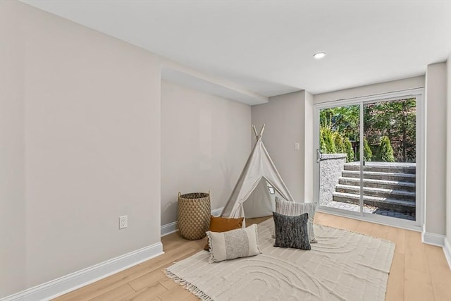 bedroom featuring baseboards, recessed lighting, wood finished floors, and access to exterior