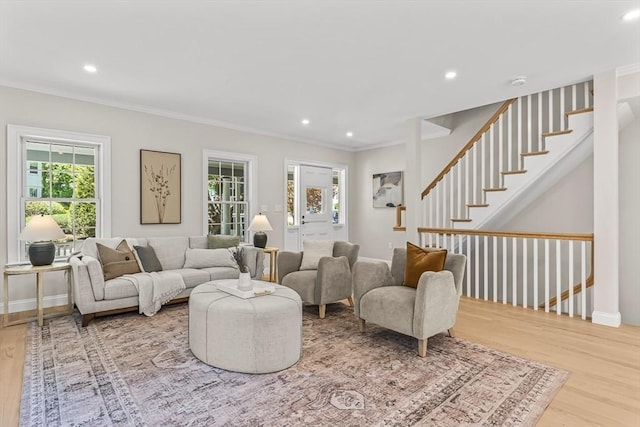 living area with wood finished floors, stairway, baseboards, ornamental molding, and recessed lighting
