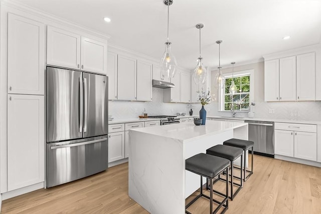 kitchen with light wood-type flooring, decorative backsplash, and stainless steel appliances