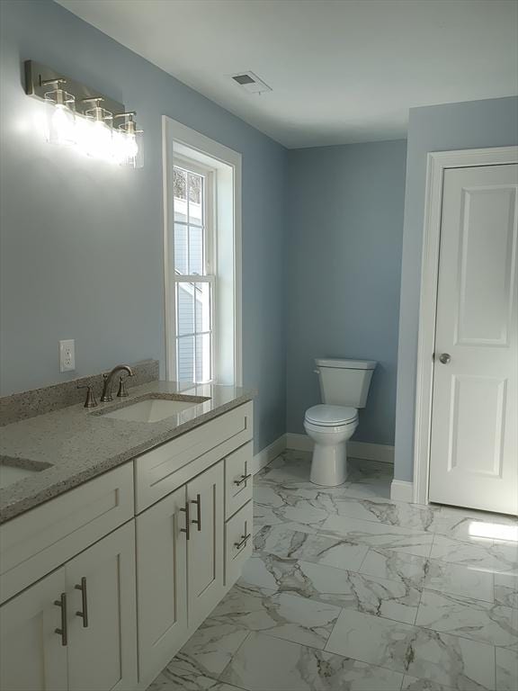 bathroom with visible vents, baseboards, toilet, marble finish floor, and a sink