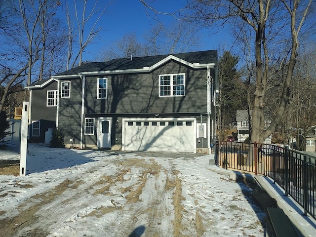 view of front of house featuring an attached garage and fence