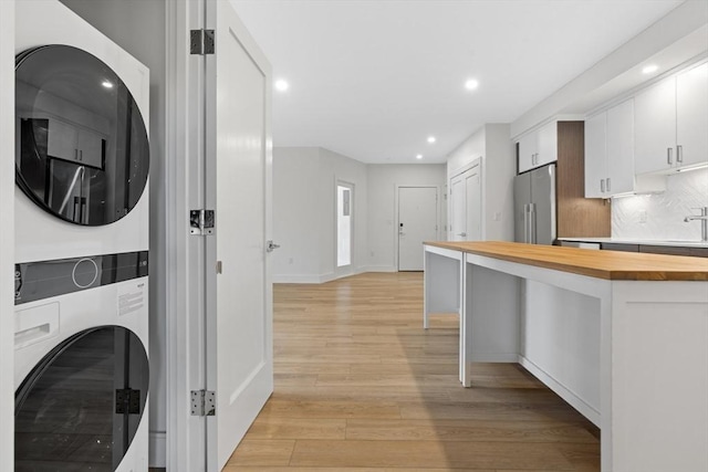 1948-1950 Washington St Unit 3E, Boston, MA 02118 - laundry area with stacked washer and clothes dryer, light wood-style flooring, recessed lighting, and baseboards