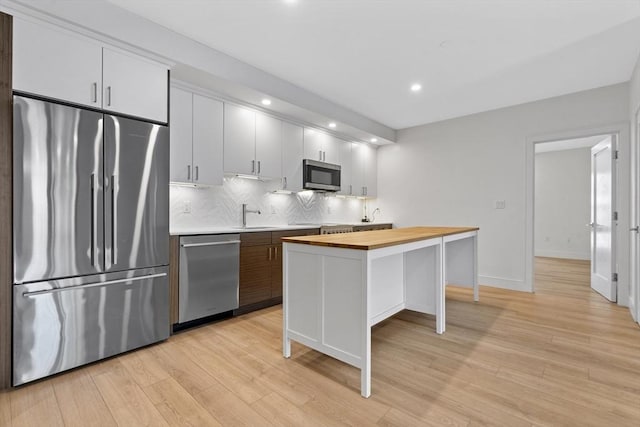 1948-1950 Washington St Unit 3E, Boston, MA 02118 - kitchen featuring stainless steel appliances, wood counters, tasteful backsplash, light wood-style floors, and recessed lighting