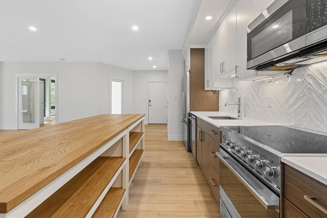 1948-1950 Washington St Unit 3E, Boston, MA 02118 - kitchen with stainless steel appliances, a sink, tasteful backsplash, recessed lighting, and light wood-style floors