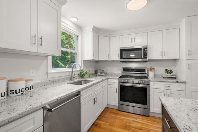 23 Redbird Rd, Wrentham, MA 02093 - kitchen with appliances with stainless steel finishes, white cabinetry, light stone countertops, and light wood-type flooring