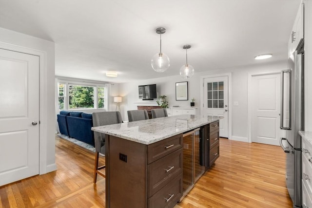 23 Redbird Rd, Wrentham, MA 02093 - kitchen featuring wine cooler, open floor plan, a kitchen bar, and light wood finished floors