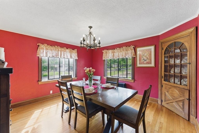 96 Craiwell Ave, West Springfield, MA 01089 - dining room featuring plenty of natural light, a chandelier, light wood finished floors, a textured ceiling, and ornamental molding