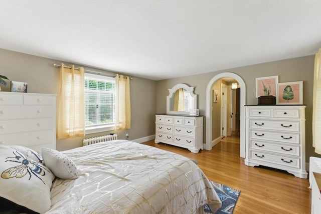 96 Craiwell Ave, West Springfield, MA 01089 - bedroom with radiator heating unit, light wood-type flooring, arched walkways, and baseboards