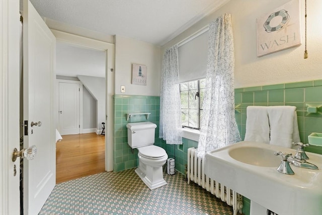 96 Craiwell Ave, West Springfield, MA 01089 - bathroom with tile walls, toilet, wainscoting, a sink, and radiator
