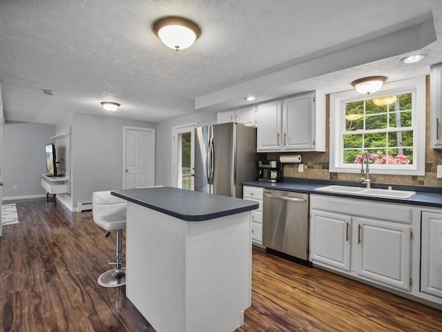 1056 Alger St, Winchendon, MA 01475 - kitchen featuring stainless steel appliances, dark countertops, a textured ceiling, baseboard heating, and a kitchen bar