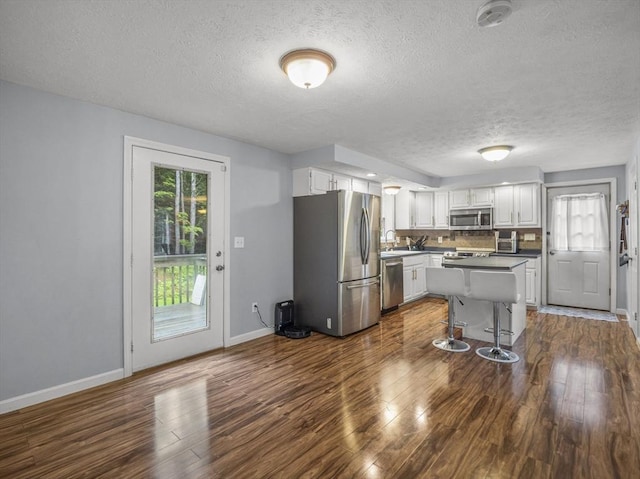 1056 Alger St, Winchendon, MA 01475 - kitchen featuring stainless steel appliances, a textured ceiling, white cabinetry, dark wood-style floors, and healthy amount of natural light