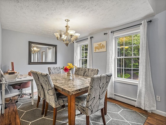1056 Alger St, Winchendon, MA 01475 - dining space featuring baseboard heating, a chandelier, wood finished floors, and a textured ceiling