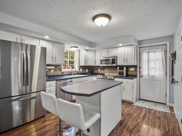 1056 Alger St, Winchendon, MA 01475 - kitchen with appliances with stainless steel finishes, dark wood-type flooring, white cabinets, and a textured ceiling