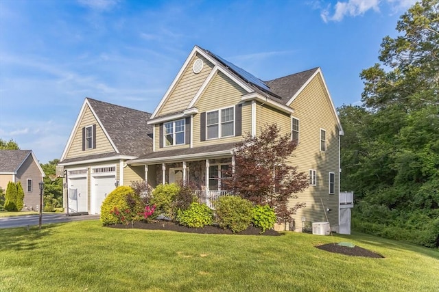 19 Crystal Cir, Tewksbury, MA 01876 - view of front facade with a porch, driveway, a front lawn, solar panels, and a garage