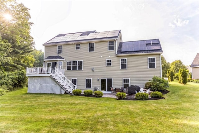 19 Crystal Cir, Tewksbury, MA 01876 - rear view of house featuring stairway, a yard, roof mounted solar panels, a patio, and a deck