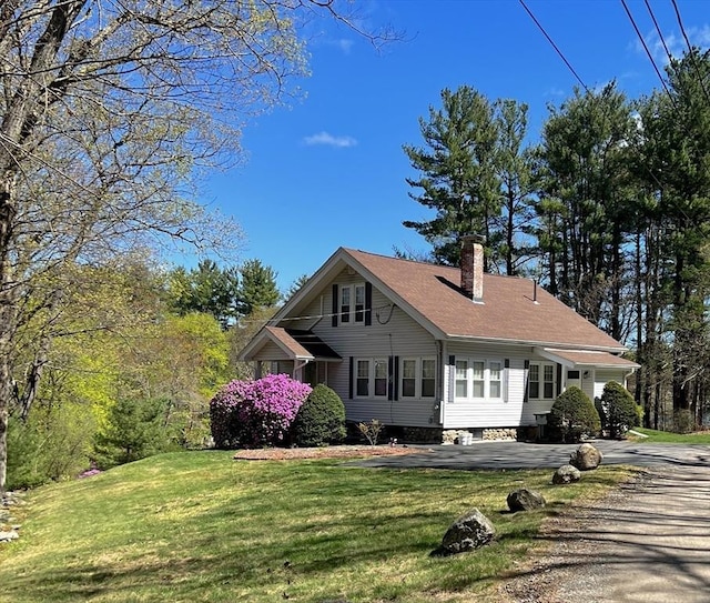 view of front of home with a chimney and a front lawn