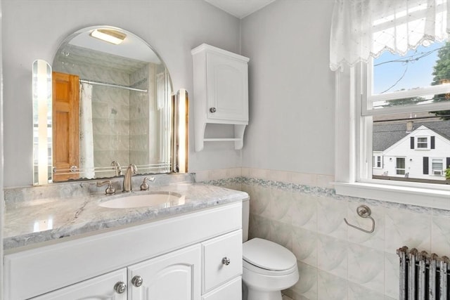 80 Joyce Kilmer Rd, Boston, MA 02132 - bathroom featuring radiator heating unit, vanity, a shower with curtain, tile walls, and wainscoting