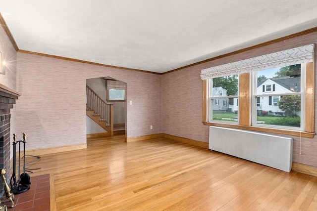 80 Joyce Kilmer Rd, Boston, MA 02132 - unfurnished living room with radiator, light wood-type flooring, a fireplace, stairs, and ornamental molding