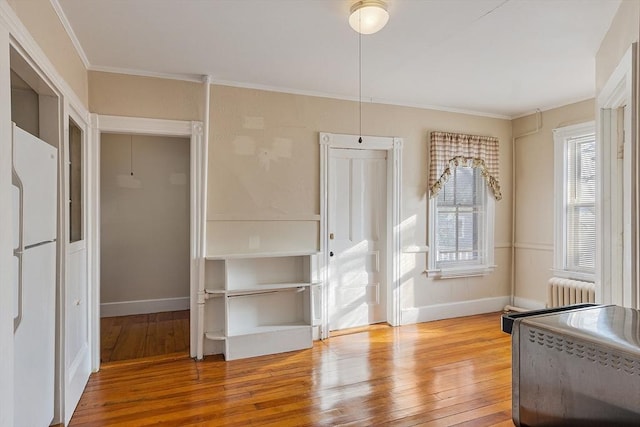 interior space featuring ornamental molding, hardwood / wood-style floors, and radiator