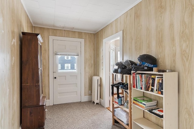 entryway with ornamental molding, carpet flooring, and radiator heating unit