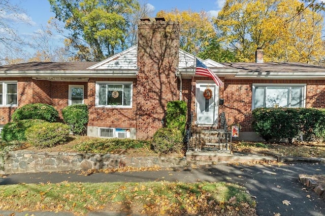 view of front facade with brick siding and a chimney