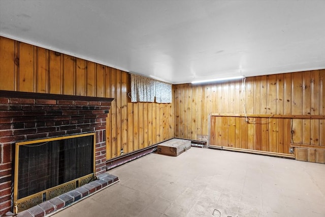 unfurnished living room featuring wood walls, a brick fireplace, and tile patterned floors