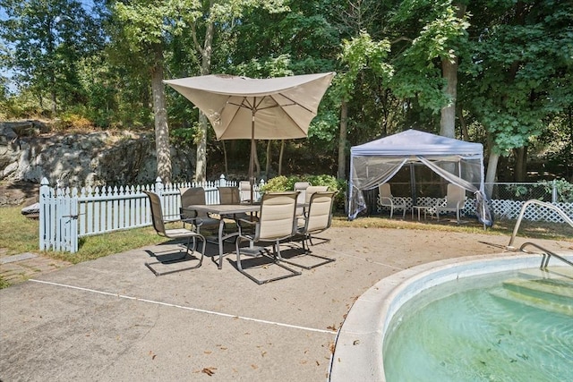 view of pool with outdoor dining space, a patio, a gazebo, and fence