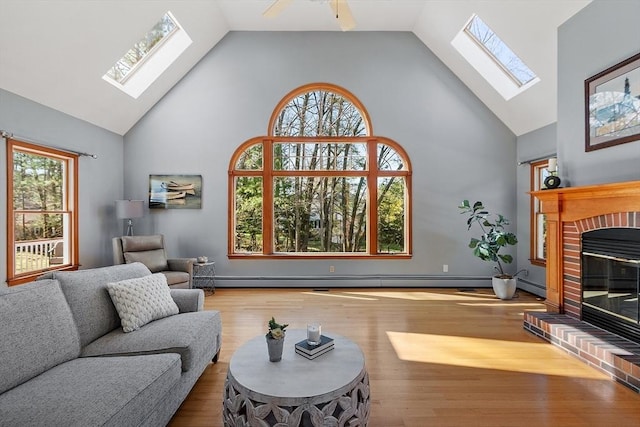 living room featuring a skylight, high vaulted ceiling, and a healthy amount of sunlight