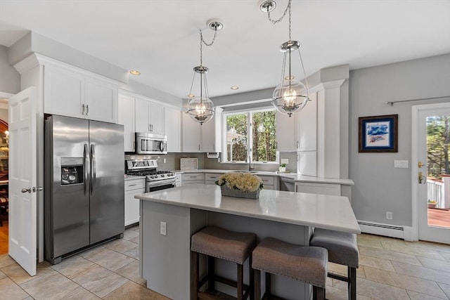 kitchen with light countertops, a baseboard radiator, a wealth of natural light, and stainless steel appliances
