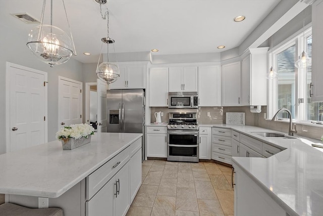 kitchen with recessed lighting, white cabinetry, a sink, backsplash, and stainless steel appliances