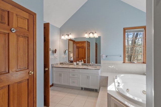 bathroom featuring a sink, tile patterned flooring, a tub with jets, and double vanity