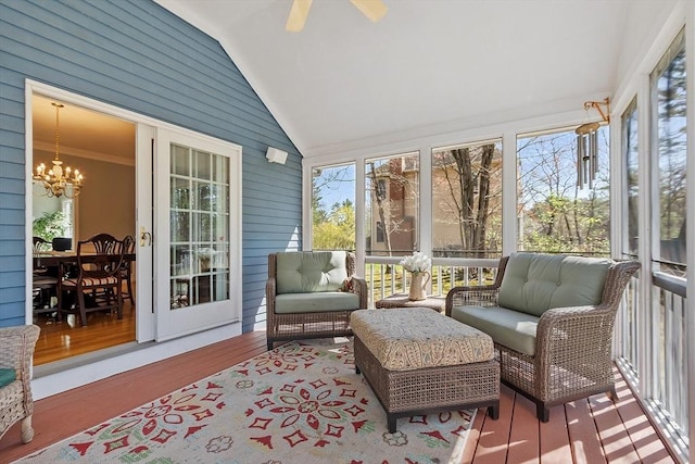 sunroom with ceiling fan with notable chandelier and an outdoor hangout area