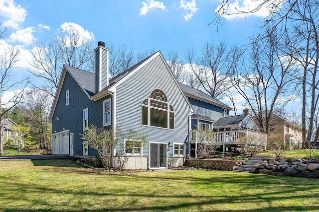 rear view of house featuring a lawn, an attached garage, a wooden deck, and a chimney