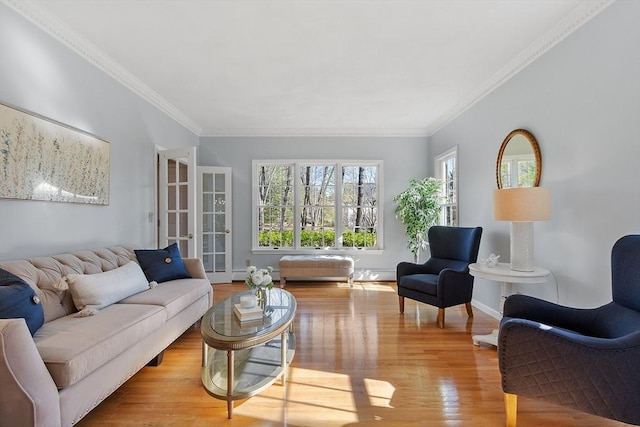 living area with crown molding, baseboards, and wood finished floors