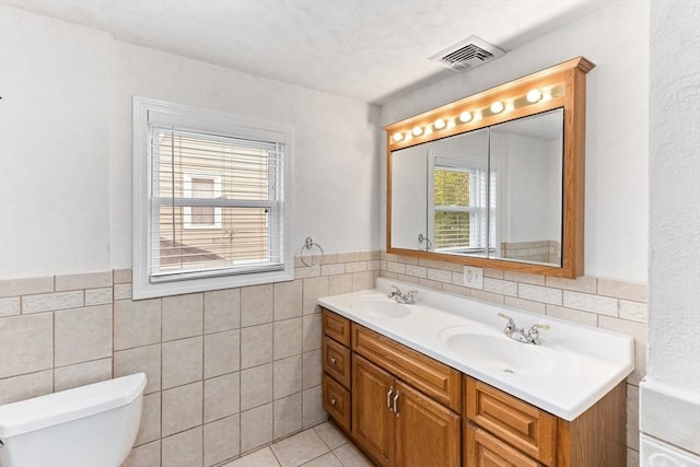 45 Curtis Ave, Attleboro, MA 02703 - full bathroom with double vanity, tile walls, toilet, a wainscoted wall, and tile patterned floors