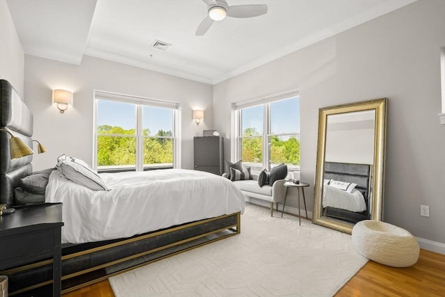 bedroom with crown molding, a ceiling fan, baseboards, and wood finished floors