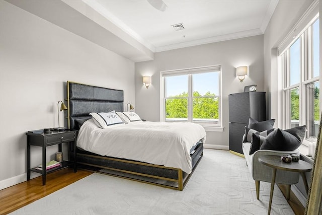 bedroom featuring ornamental molding, baseboards, and wood finished floors
