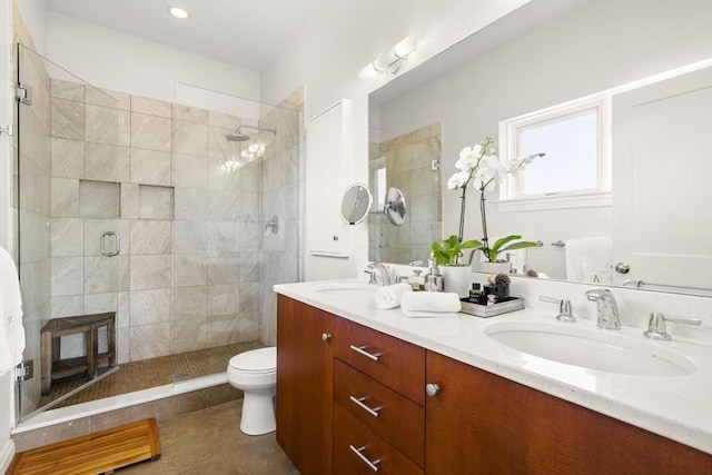 full bathroom with a stall shower, double vanity, toilet, and tile patterned flooring