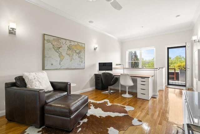 office space with crown molding, wood finished floors, baseboards, and a ceiling fan
