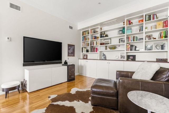 living room featuring light wood finished floors and ornamental molding