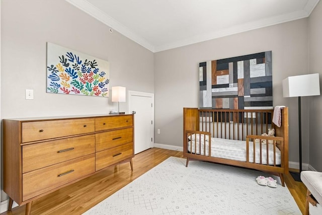 bedroom featuring ornamental molding, light wood-style floors, and baseboards