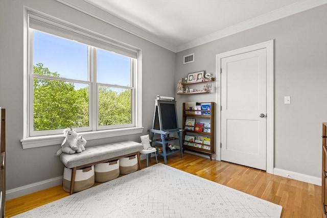 living area featuring crown molding, plenty of natural light, wood finished floors, and baseboards