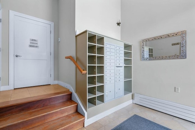 stairs featuring tile patterned floors, baseboards, and a baseboard heating unit