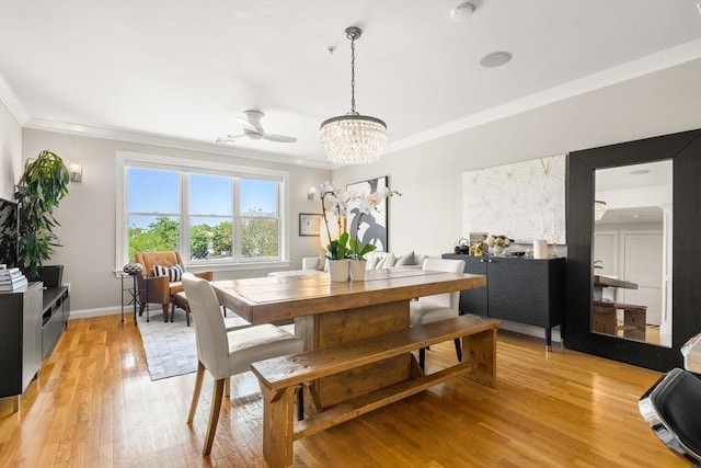 dining space with ornamental molding, light wood-style flooring, a chandelier, and baseboards