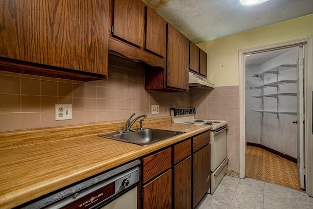 kitchen with white appliances, light tile patterned flooring, and sink