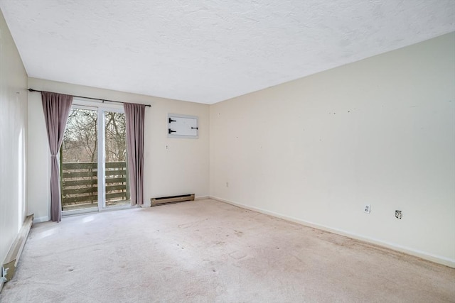 spare room featuring a baseboard heating unit, a textured ceiling, and light carpet