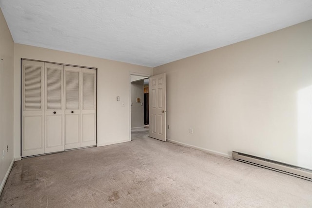 unfurnished bedroom with a baseboard heating unit, a closet, and light carpet