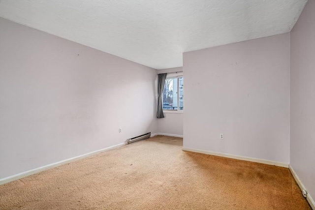 spare room featuring a baseboard radiator and carpet floors