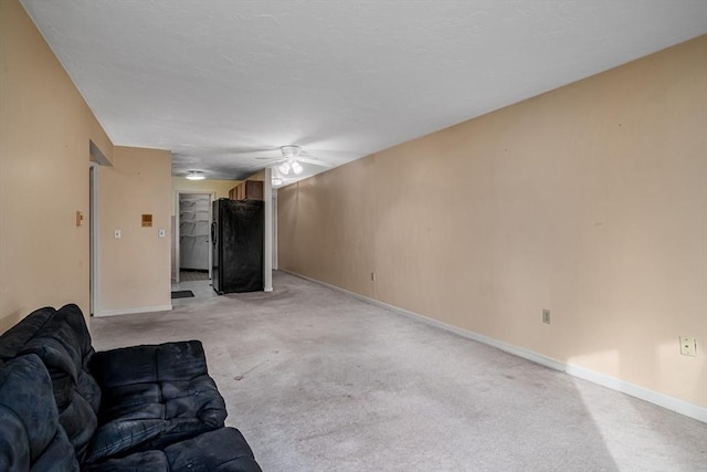 unfurnished living room featuring ceiling fan and light colored carpet