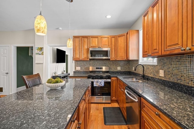 34 Prout St, Quincy, MA 02169 - kitchen featuring appliances with stainless steel finishes, a sink, brown cabinets, light wood-style floors, and tasteful backsplash